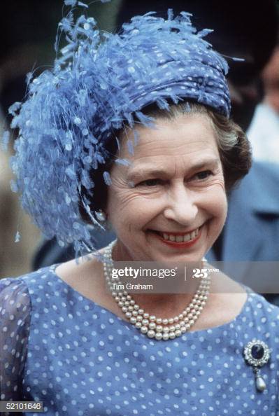 Queen Elizabeth wears a blue pillbox hat with feathers